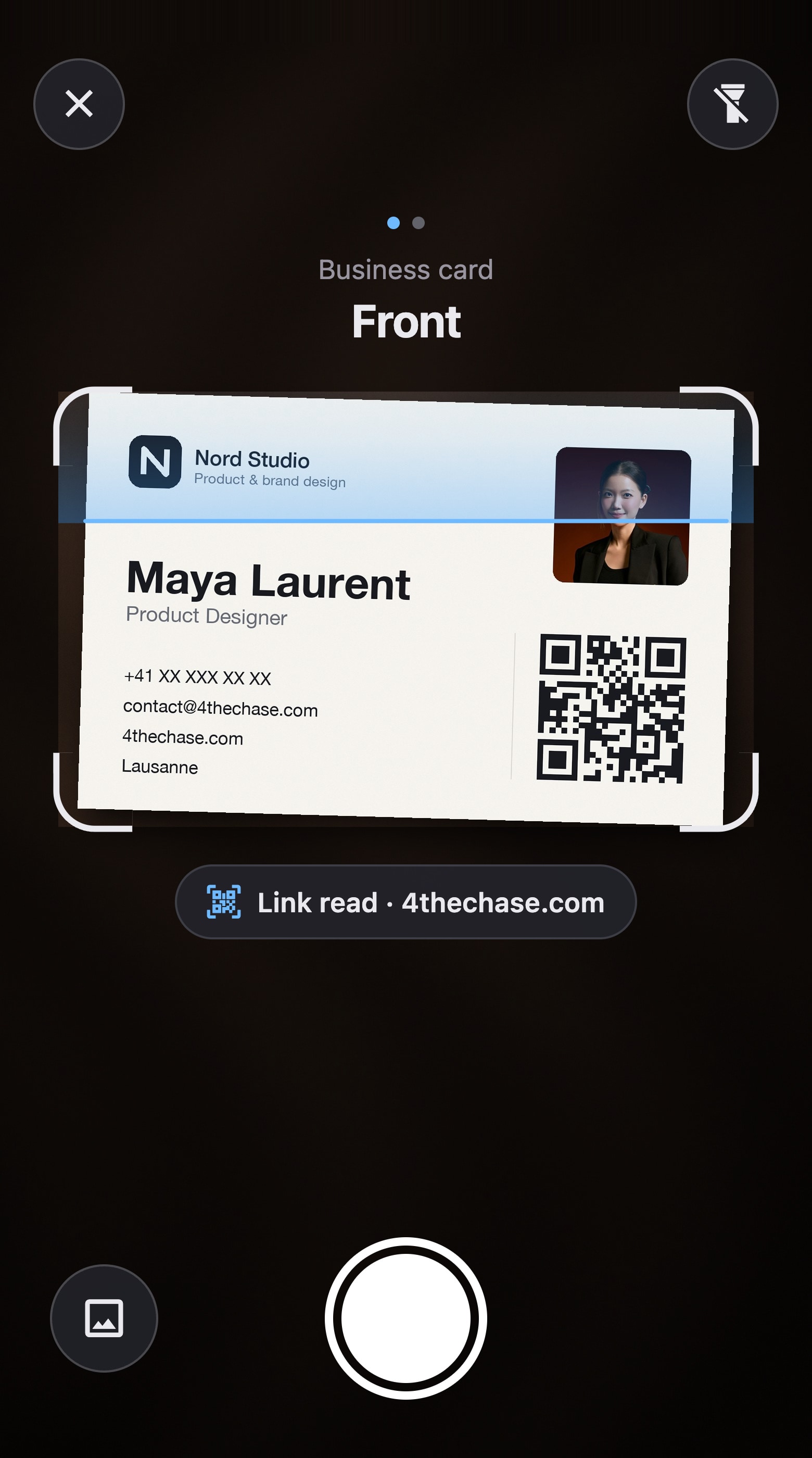 The app's viewfinder: Maya Laurent's business card in the frame, and its QR code already read